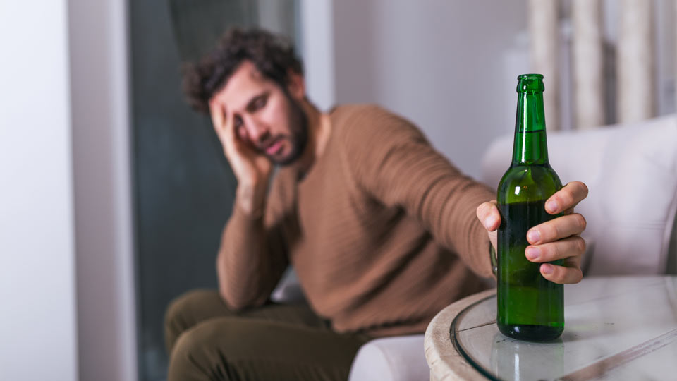 https://www.therapmed.ch/wp-content/uploads/2021/11/after-work-a-depressed-guy-sitting-on-sofa-drinking-a-cold-beer-hand-holding-a-glass-man-drinking-home-alone-alcoholism-alcohol-addiction-and-people-concept.jpg