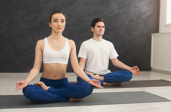 https://www.therapmed.ch/wp-content/uploads/2021/11/attractive-couple-practicing-yoga-sitting-in-padmasana-young-man-and-woman-in-lotus-pose-doing-breathing-exercise-on-mat-at-sport-club-interior-copy-space.jpg