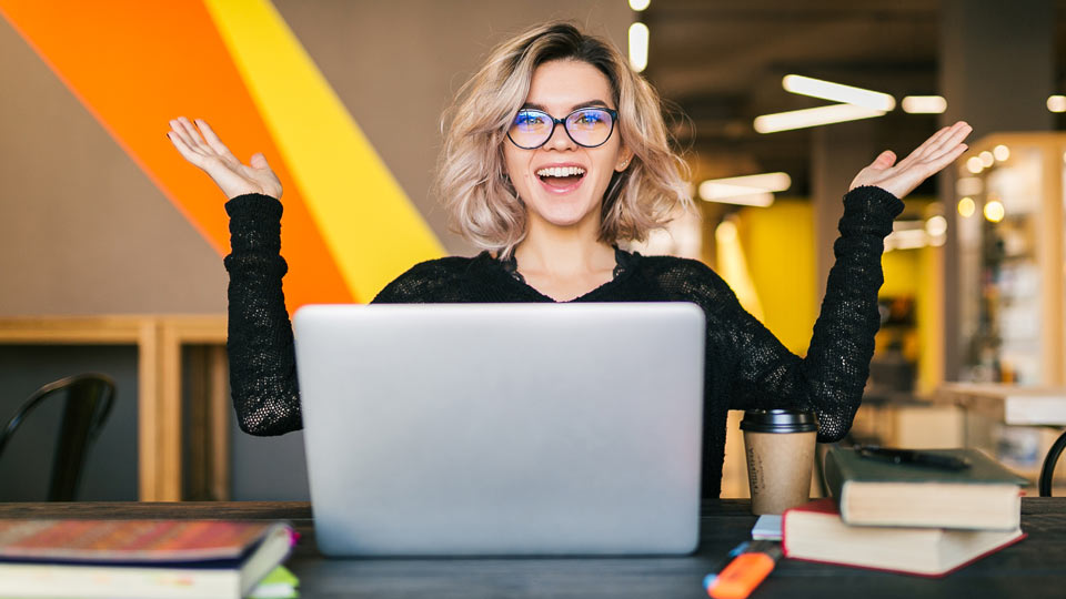 https://www.therapmed.ch/wp-content/uploads/2021/11/funny-happy-excited-young-pretty-woman-sitting-at-table-in-black-shirt-working-on-laptop-in-co-working-office-wearing-glasses.jpg