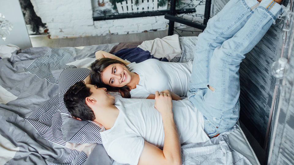 https://www.therapmed.ch/wp-content/uploads/2021/11/portrait-of-happy-couple-relaxing-in-bed-and-holding-hands-and-legs-at-morning.jpg