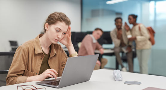 https://www.therapmed.ch/wp-content/uploads/2021/11/portrait-of-stressed-young-woman-using-laptop-in-office-or-coworking-space-with-group-of-people-in-background-copy-space.jpg