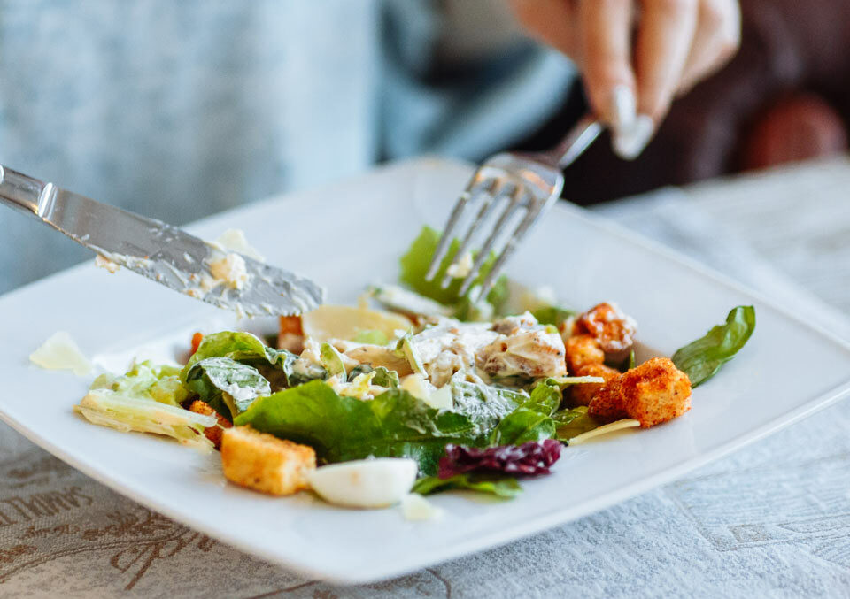 https://www.therapmed.ch/wp-content/uploads/2021/11/woman-s-hands-with-caesar-salad-on-table-in-restaurant-e1642766336699.jpg